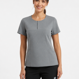 Modelo muestra Uniforme clínico gris vista frontal con dos broches, bolsillos y corte cómodo
